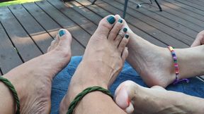 Barefoot couple with painted toes plays footsie outside
