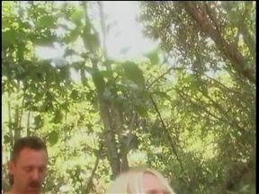 Busty blonde's arms are held be behind her back as she is fucked in the woods