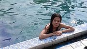 Solo Asian Woman Relaxing in a Crystal-Clear Pool