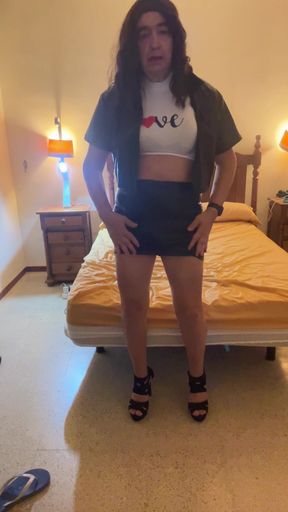 Beautiful and sexy Spanish trans girl masturbates in a tight miniskirt and black latex jacket in the bedroom, wearing high heels