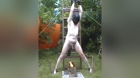 Chained naked male slave gets his cock and balls roasted