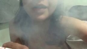 Amateur brunette girl smokes cigarette and fingers her pussy