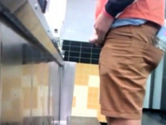 Guys in the urinals taking leak.