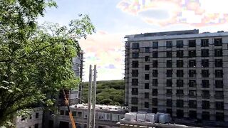 An exhibitionist GIRL walks on a construction site