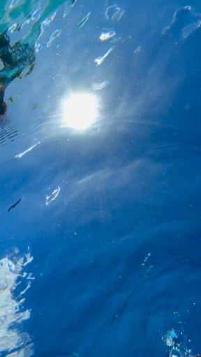 Underwater view from below with self-touch and bubbles in face and on chest