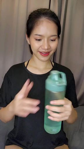 Female Asian adult in studio holding water bottle