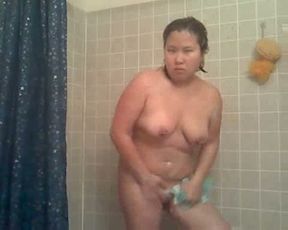 Chubby Asian brunette woman filming herself in the shower