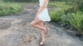 A girl in high-heeled sandals walks on slippery mud and slides (re-realize)