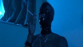 Topless Black Mistress smoking in latex mask