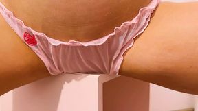 Raven-haired vixen thrusts hips against the table edge, pink lingerie a blur.