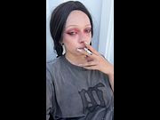 Smoke curls from her lips as she holds the joint 💕