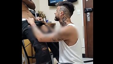 Ajoelhado na frente do cliente medindo o local da tatuagem