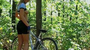 Booty blonde is posing near her bike deep in the forest