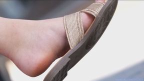 Candid dirty feet slippers dangling, hot feet and shoes close-up.