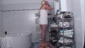 Bathroom balancing on human mat while applying her make up