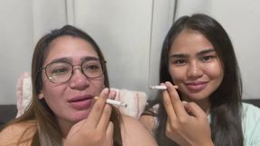 2 Asian girls smoking on the couch