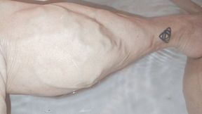 Veiny calves up close in tub