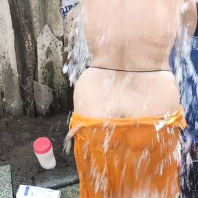 Indian house wife bathing outside