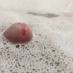 Uncut cock comes up through the foam in the water