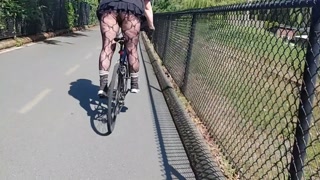 Following woman in mini skirt and fishnets biking