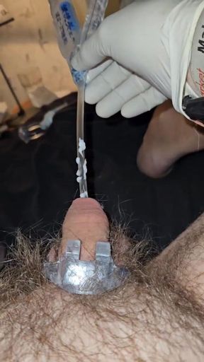 Inserting a catheter into the penis while wearing surgical gloves