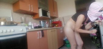 Sexy wife having fun in the kitchen with roses. Sexy naked wife preparing food in the kitchen.