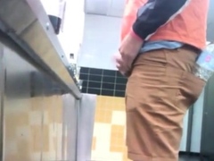 Guys in the urinals taking leak.