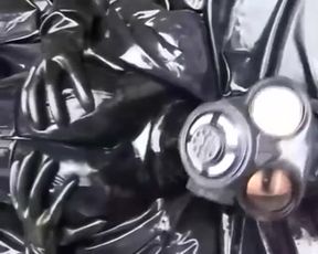 Latex girl full in black rubber and Gasmask chill outs outdoor in garden in a heavy rubber hammock