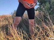 Locked in chastity cage cyclist man is pissing outdoor