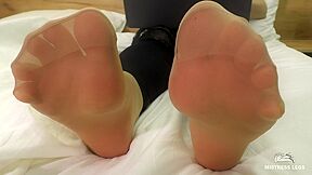 Mistress Feet In Soft Nylon Socks Is Resting On The Bed