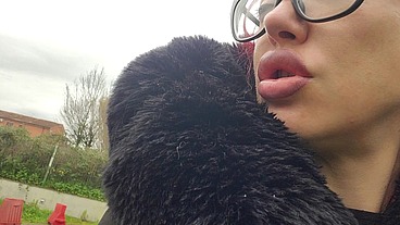 "A red-haired woman with full lips sits on a park bench, letting out loud burps without a care in the world