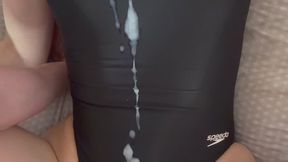 Covering black Speedo swimsuit with cum