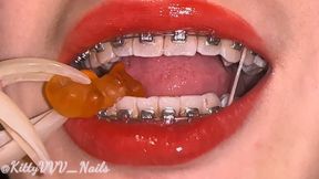 Crushing gummy bears with my vampiric sharp white teeth (with braces and long nails)