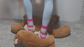 Mickee tramples big stuffy in slippers and pink fuzzy socks