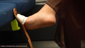 Candid dirty big feet and slippers dangling close-up, bratty woman with soles on train seat.