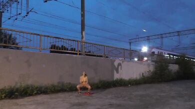 Crazy girl jerks off in front of a train and pisses on the tracks