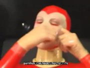 Sexy girl encased in red rubber catsuit loves medical games with mouth spreader and nipple clamps