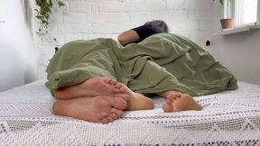 female male bare feet under the blanket