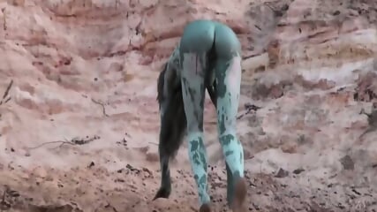 teen girl plays in some green mud