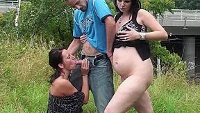 Two brunettes share a cock in nature