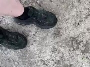 Dirty sneakers stepping on pine cones in the park