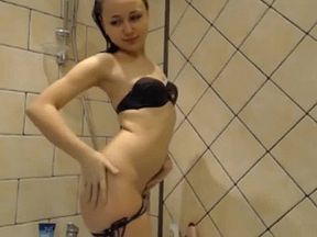 Nastya in a black bikini washes in the shower with a laptop