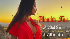 Monika Fox looks stunning in her red suit as she poses in the mountains.