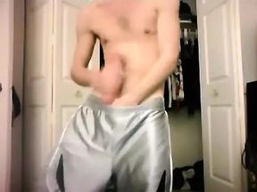 Gay guy in silver dazzle shorts masturbates on camera.