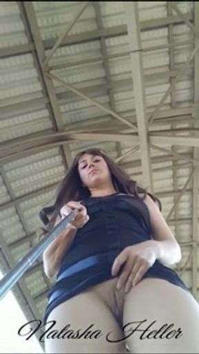 A beautiful, young exhibitionist girl in a transparent dress shows her pussy at the railway station.