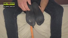Tickling black socks on bed