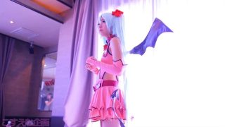 Een cosplayer van Sweet Devil Miku wordt door twee gemaskerde mannen vingerneukt.