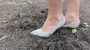 A girl gets a lot of pleasure from crushing her shoes in the mud