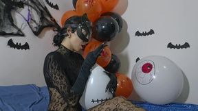 Catwoman on Halloween bursts balloons with her claws