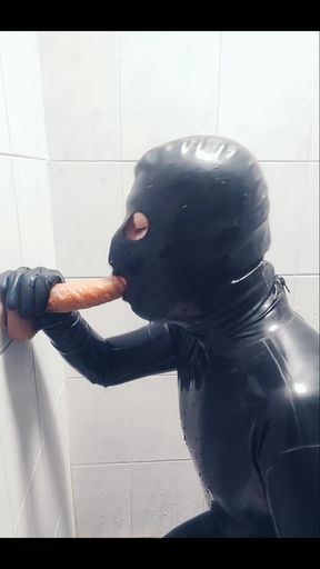 Rubber boy playing with a dildo in chastity p1